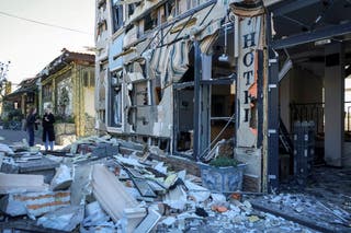 Residents stand at the site of a hotel hit by a Russian drone strike in Odesa, Ukraine April 27